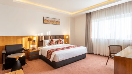 A double bed, seating area and windows
