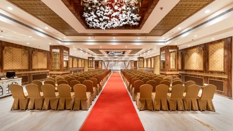 The expansive Raj Mahal banquet hall showing a professional theatre-style seating arrangement, ornate ceilings, and a central red carpet – Skkylight Lords Inn, Nanded
