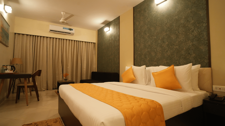 A double bed room with lamps, study desk with chair, and rug