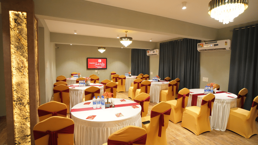 A class room style seating arrangement wit TV, AC, windows with curtains and lighting