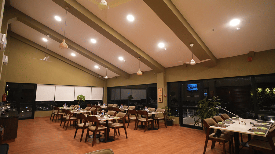 A restaurant seating arrangement with ceiling lights and wooden floor