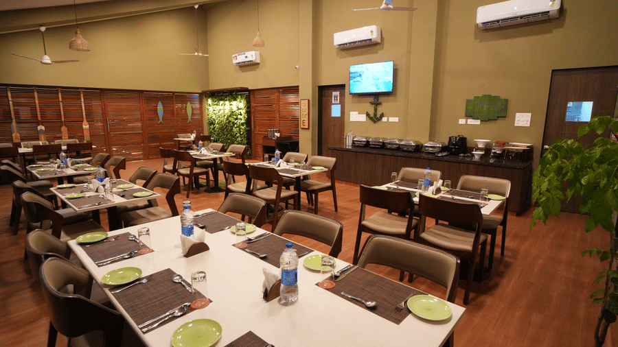 A restaurant seating area with chairs and tables, TV and AC