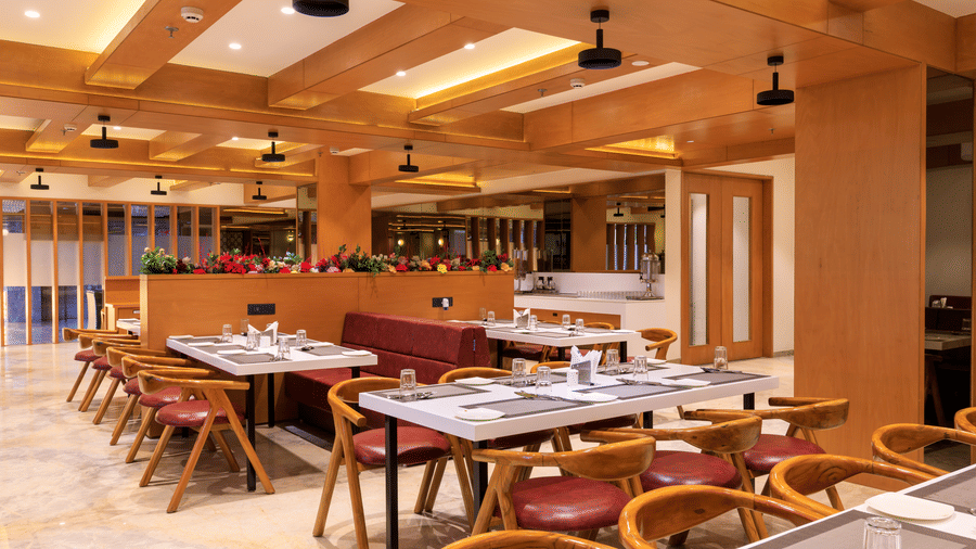 A restaurant seating area with chairs, tables set for diners