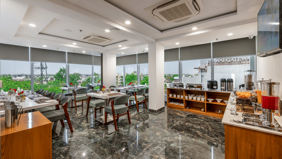 Spacious BCR restaurant dining area with large windows, multiple tables & chairs and the marble flooring.