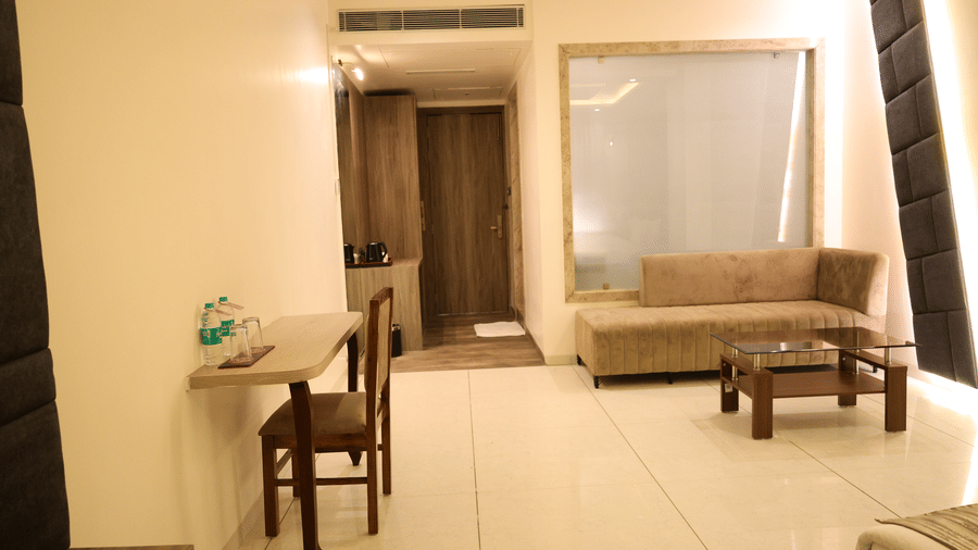 A cosy seating area features a beige sofa and a small wooden coffee table - Lords Inn Sangam, Bhopal