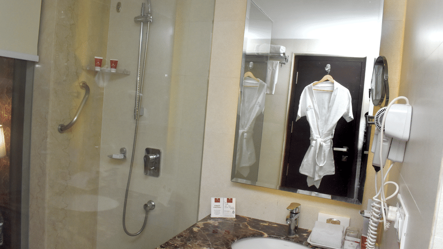 A modern bathroom with a glass shower cubicle and sink area at Lords Plaza Surat.