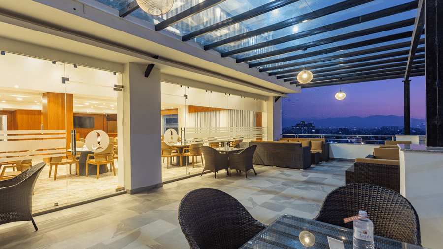 Outdoor seating arrangement at Mandala by Lords featuring a spacious corridor with a covered ceiling and picturesque views.