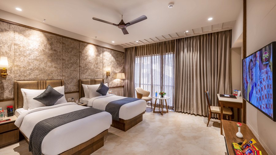 Full view of the Executive Room featuring twin beds facing towards the wall-mounted television above the TV cabinet - Skkylight Lords Inn, Nanded