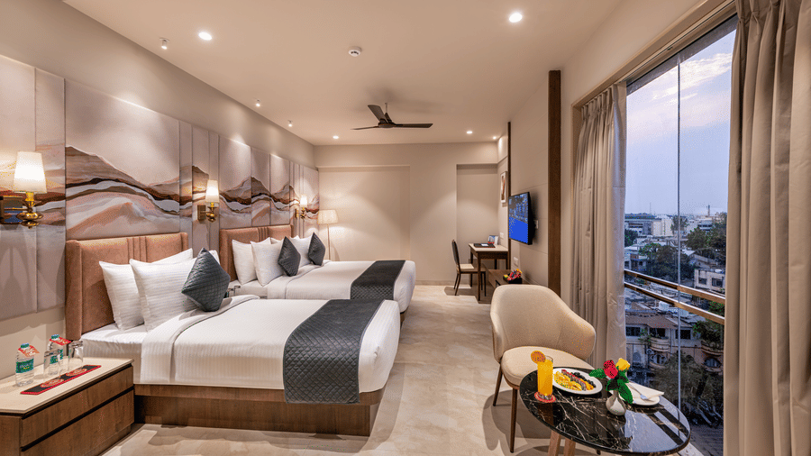 Side view of the Family Room overlooking the city views under the evening sky through the large windows - Skkylight Lords Inn, Nanded
