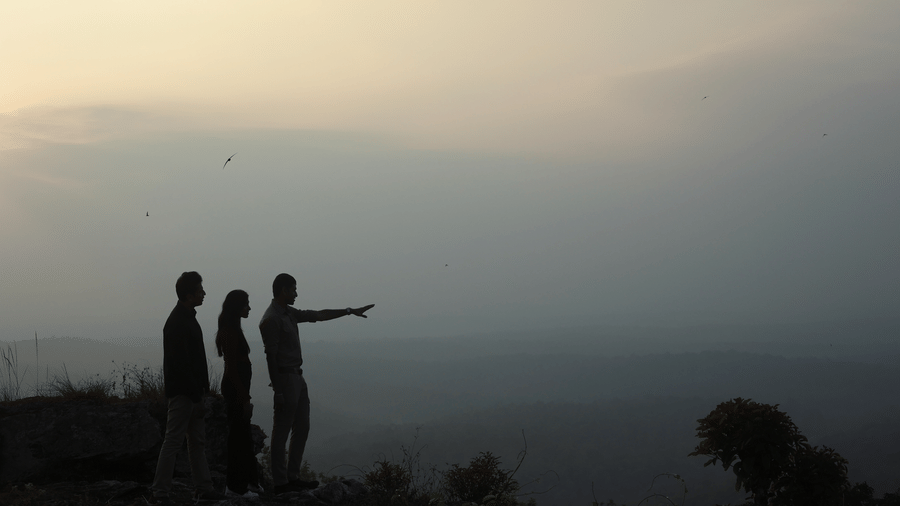 Silhouette of two guests watching a dramatic sunset near Evolve Back Coorg