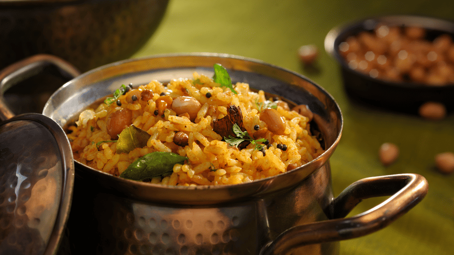 Traditional Indian dal served in brass pot at Evolve Back Hampi restaurant