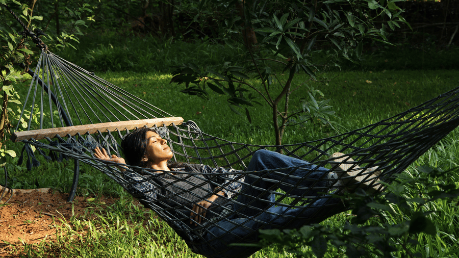 Guest relaxing in a hammock amid jungle greenery at Evolve Back Kabini