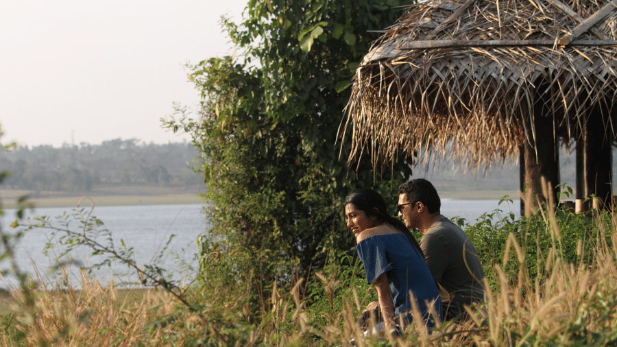 Guests enjoying sundowners on a thatched deck by the Kabini river at Evolve Back Kabini