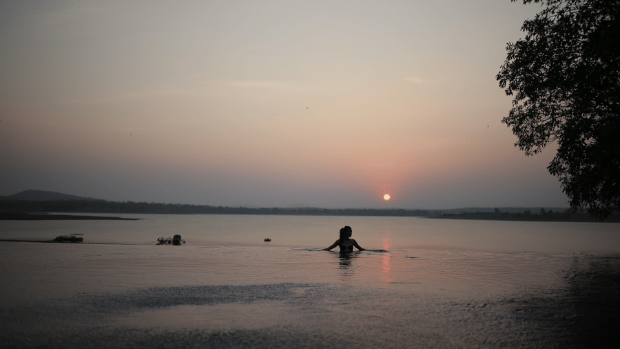 Local children swimming in the Kabini river at sunset near Evolve Back resort