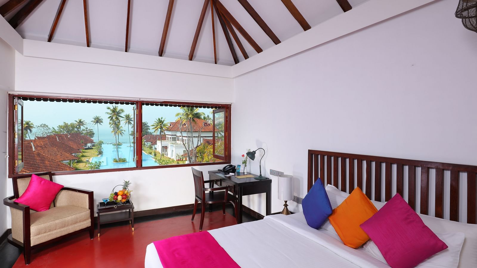 an image of a Lake View Terrace Suite with a comfortable bed , a working desk and a sofa with a swimming pool view from the room - at Rhythm Kumarakom