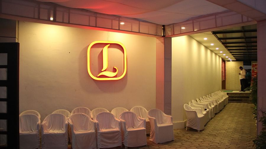 Outdoor event area at night with white seating and illuminated logo