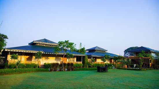 A facade image of The Baagh Ananta Elite, Ranthambore with a lawn in front
