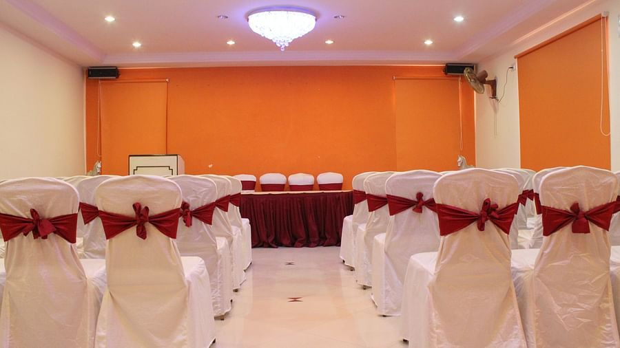 Hotel Yasodha Towers - interior view of a mini party hall in hosur featuring chairs decorated with satin cloth and lined in 4 columns