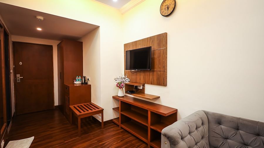 Executive room with television, sofa and wooden floor at Vagator Downtown, Goa 