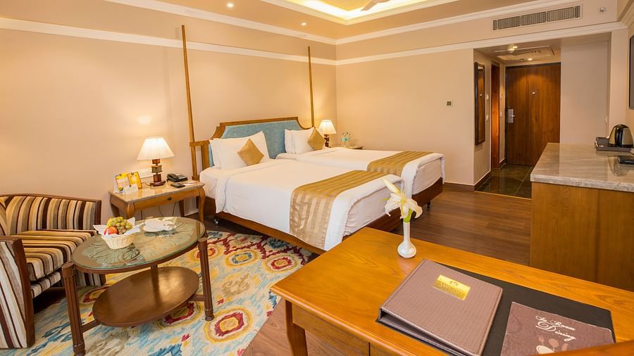 Spacious bed with wooden furniture surrounding the room for storage and relaxation.