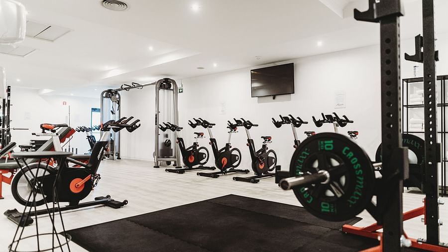 Bright, cool lighting with various gym equipment neatly arranged.