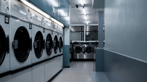 a row of washers and dryers at a laundry facility