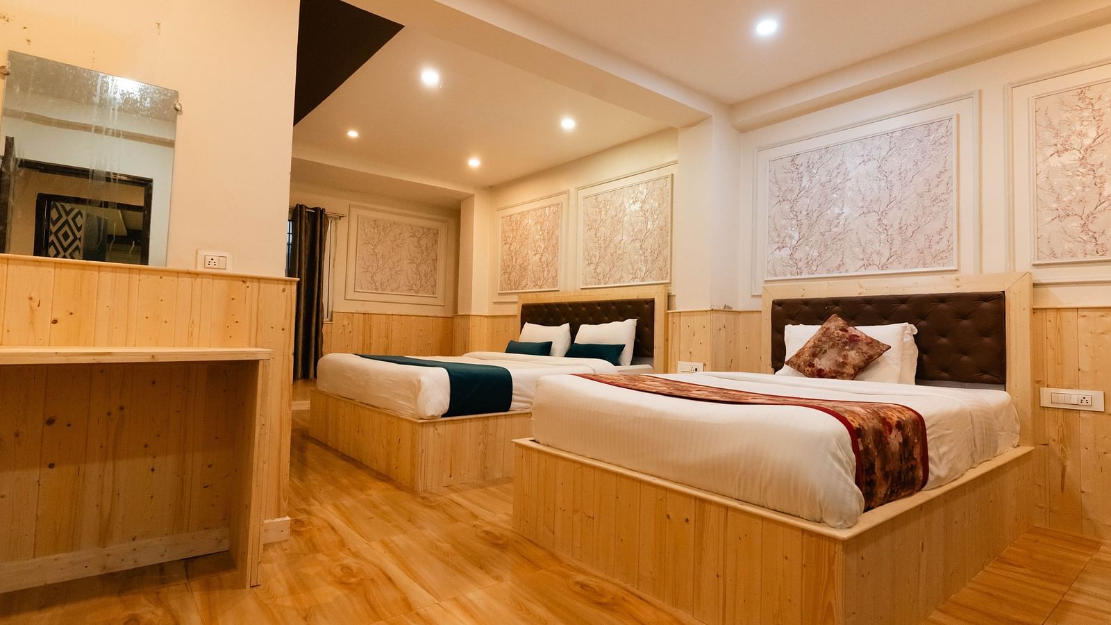 an image of a bedroom with one king size bed and one single bed placed closely at an image of a bedroom with wooden strips flooring at Avianna New Mandala Hotel & Spa, Darjeeling