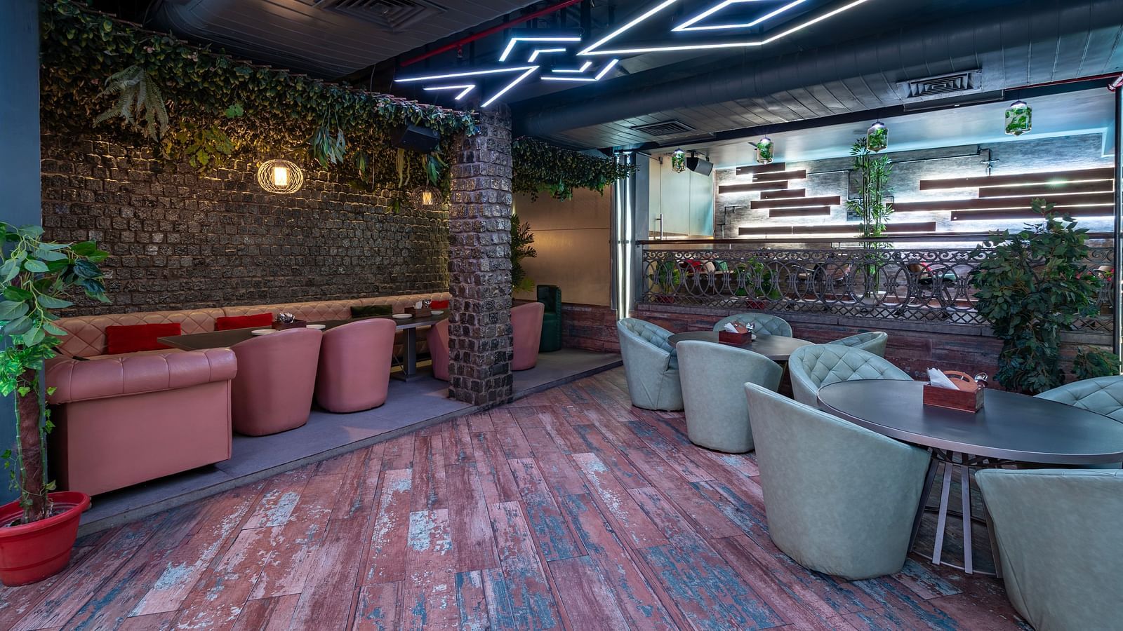 Interior view of the restaurant at Hotel Moti Palace, featuring comfy sofas, warm ambient lighting, and decor with lush plants