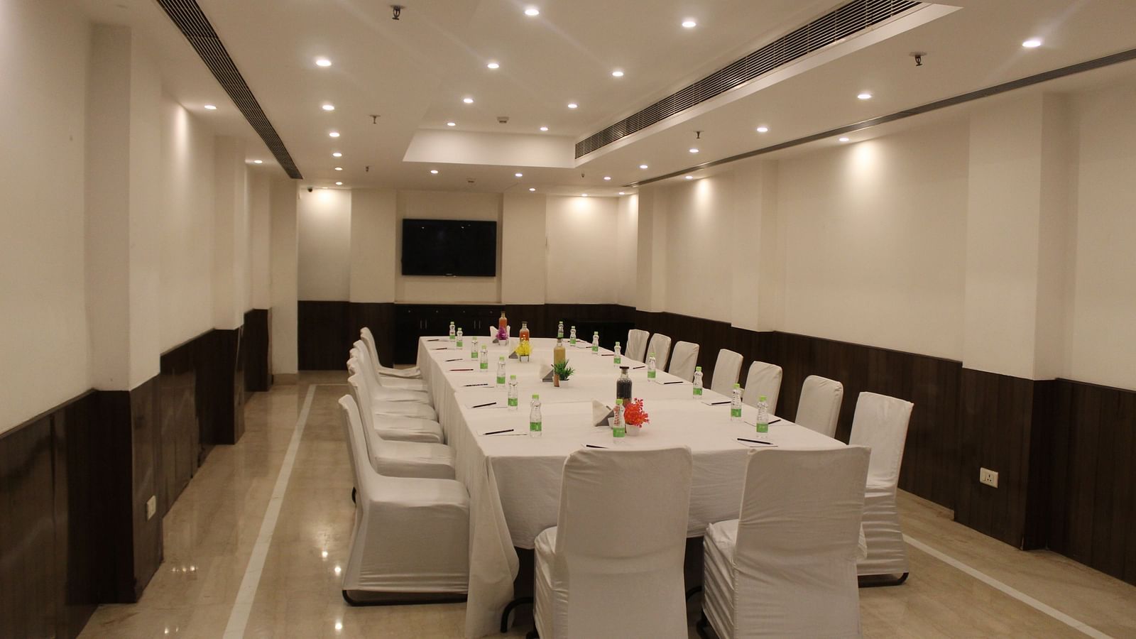 An image of a conference room at Inde Hotels Vista Woods featuring a huge table surrounded by several chairs