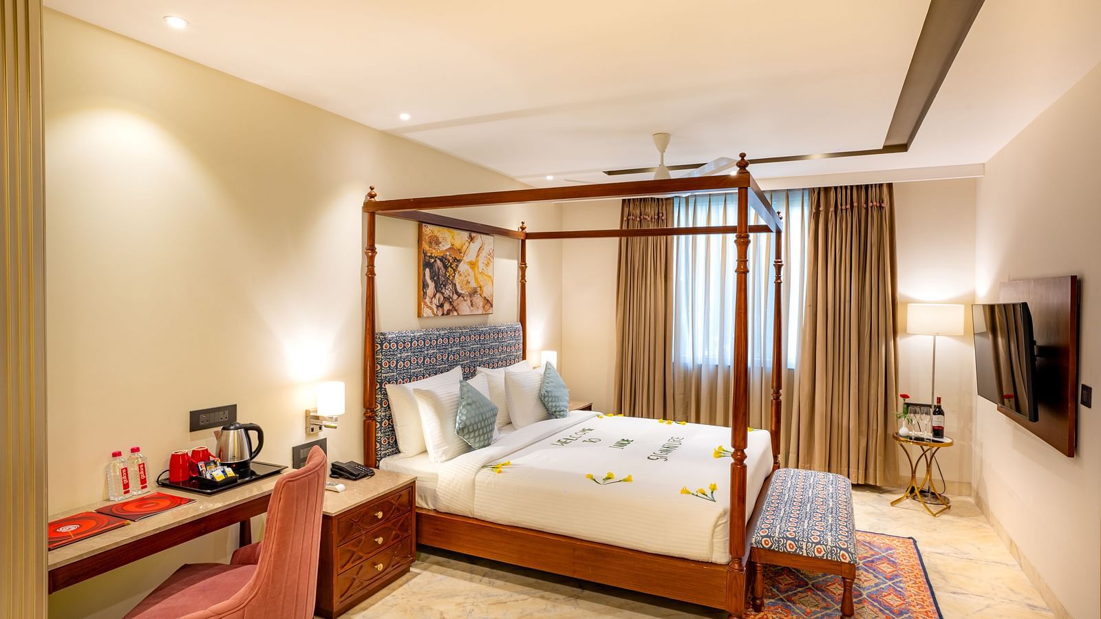 Spacious Suite with double bed, wooden bed side table, wall mounted television, big window with curtains at Inde Signature Jaipur