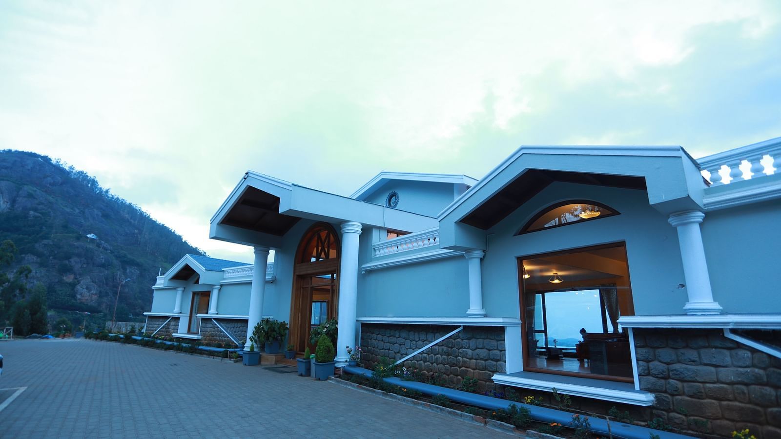 facade of La Montana By TGI, Ooty surrounded by mountains during daytime