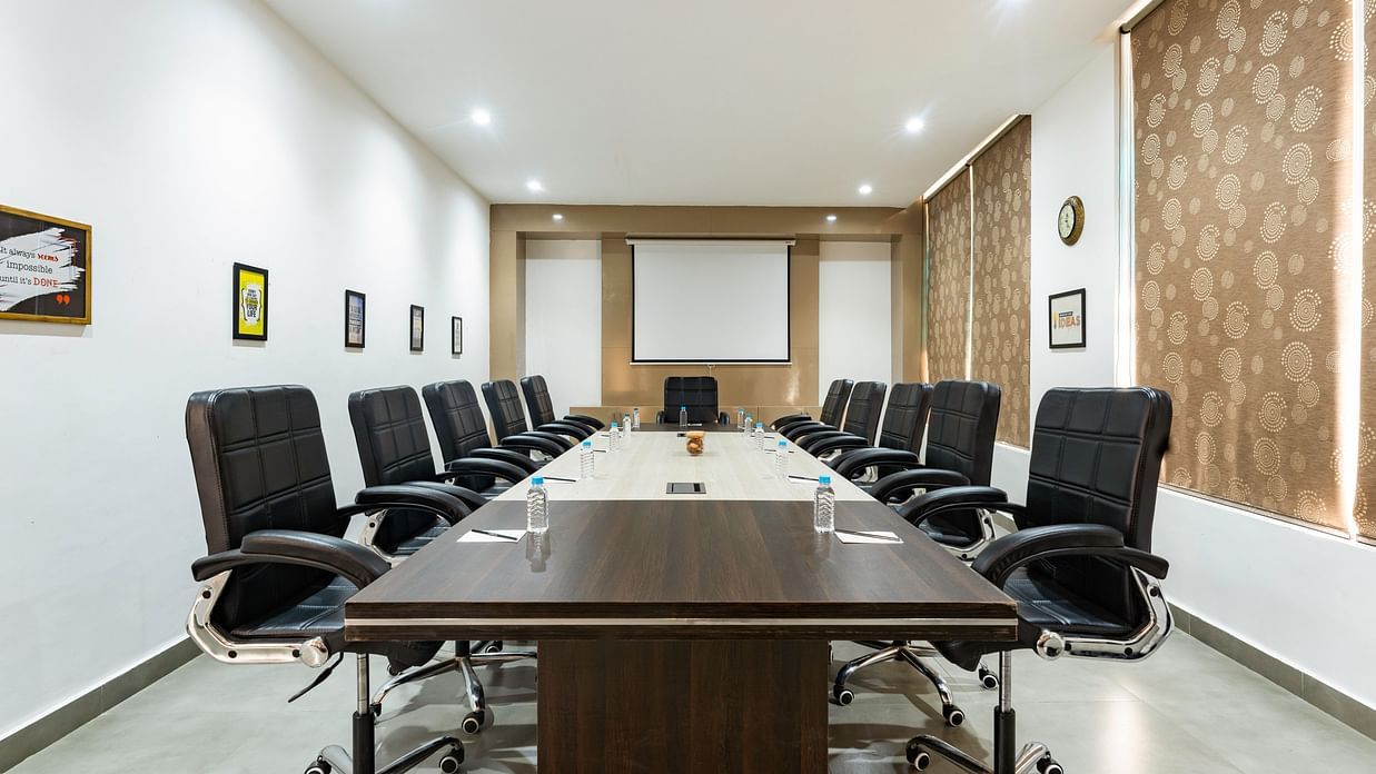 A modern conference room features a large table and comfortable chairs.