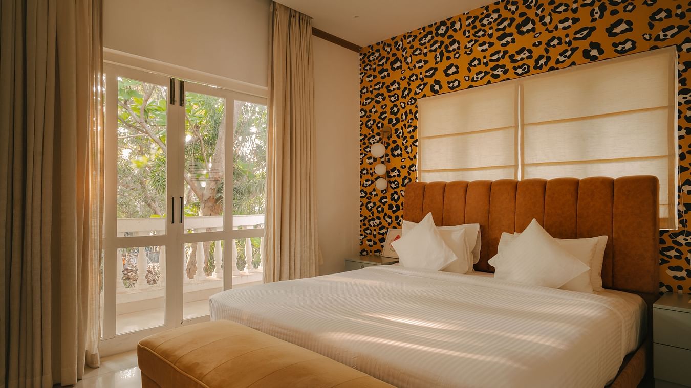 Luxurious bedroom featuring warm lighting and a patterned accent wall at Richmonde Ananta Elite, Goa.