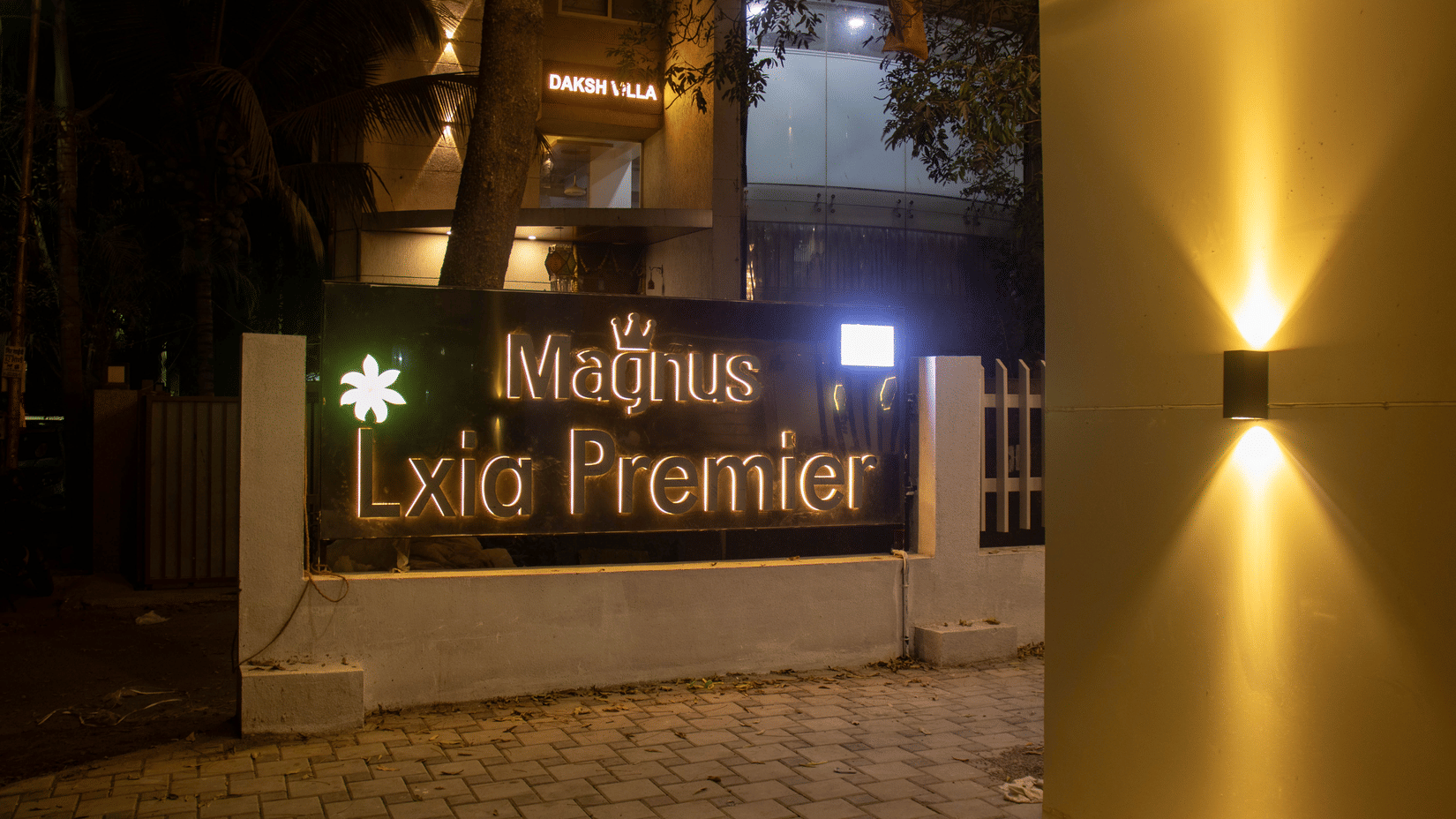 The hotel entrance signage and gate area at night at Magnus Lxia Premier, Kalyani Nagar.