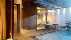 Pool villa at Uday Backwater Resort with a private pool, wooden deck, lounge chairs, and warm ambient lighting during a rainy evening
