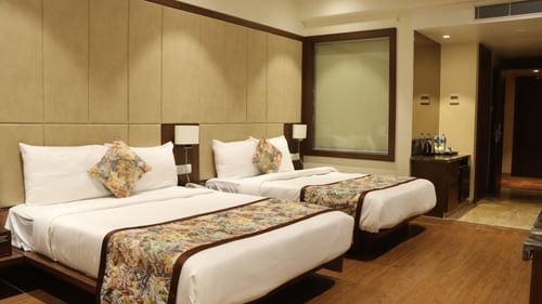 Premium Room T Pride Hotel Bhopal featuring two bed placed next to each other with a large headboard covering almost entire wall