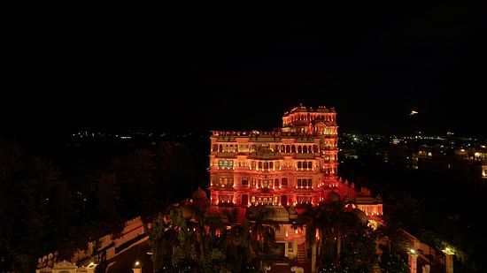 A palace lit up with lights during the night with darkness in the background - Chunda Hotels