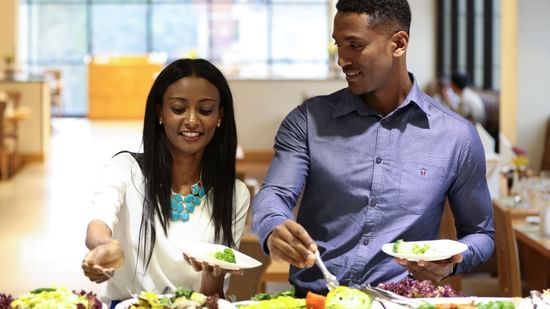 A couple taking food from the buffet area inside one of the restaurants at Ramada by Wyndham Addis, Addis Ababa.