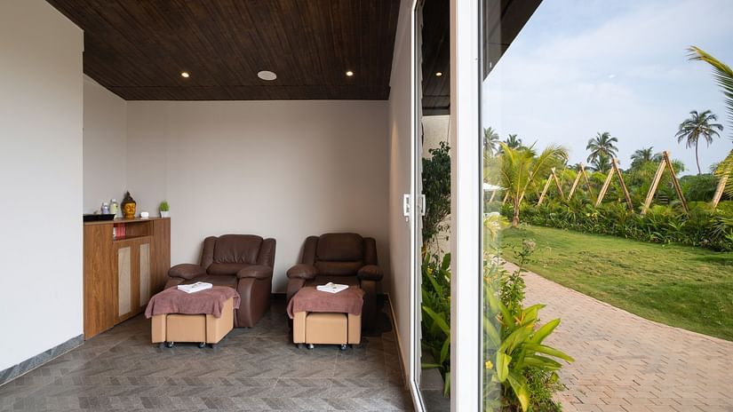image of the spa with two cushioned massage chairs besides lush green lawn 