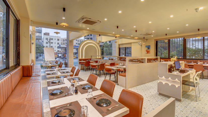 Elite Restaurant at VITS Select Nashik Hotels & Resorts featuring tables arranged under warm lighting with cutlery placed
