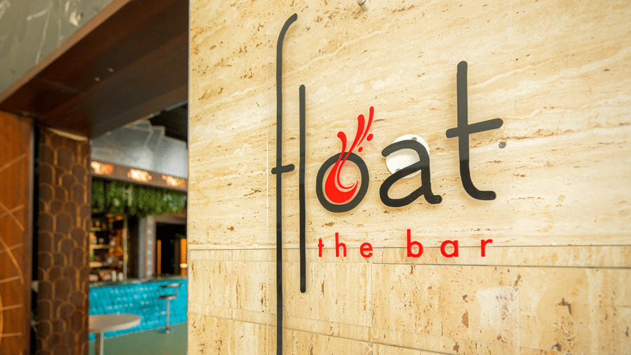 Entrance sign for Eat the Bar set against a textured stone wall near the hotel dining area.