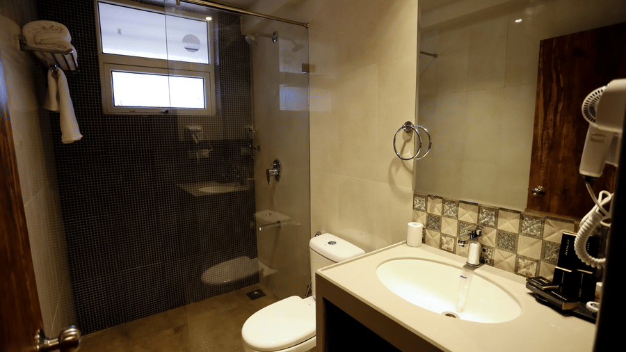 A washroom with a sink and a toilet on the side at Amara Grand Baga, Goa.