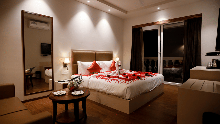 Side view of a room with a bed and a mirror on the side at Amara Grand Baga, Goa.