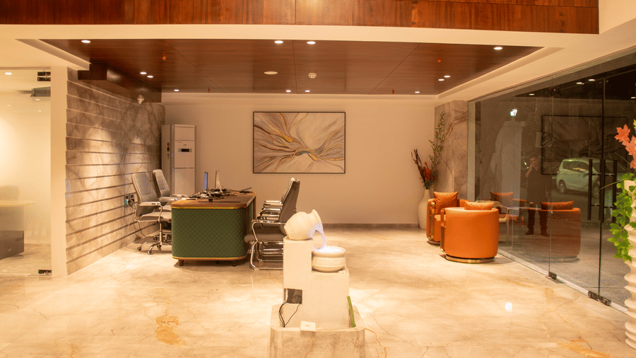 The lobby area with 2 armchairs, reception desk, chairs, and marble sculpture at Magnus Lxia Premier, Kalyani Nagar.