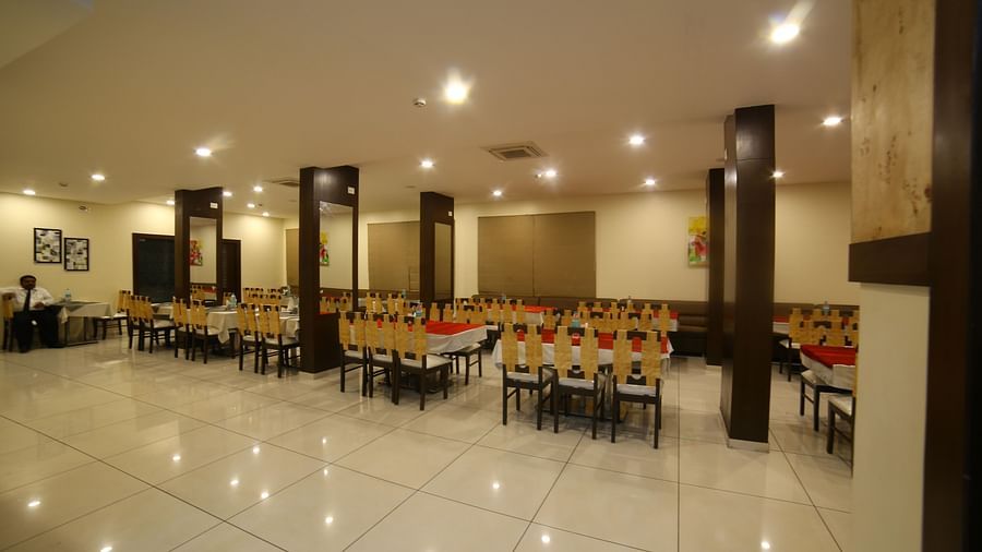 Mysore Gate Hotel, Bangalore Bengaluru A restaurant featuring a bunch of tables and chairs - Mysore Gate Hotel Bangalore