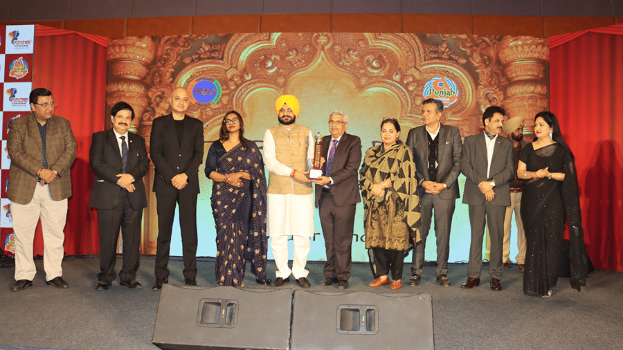 A group of people on a stage with ambient lighting and professional attire during an award ceremony