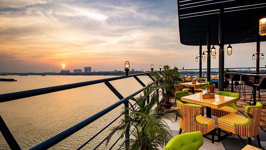 a view of river hooghly from the deck as the sun sets in the background - polo floatel kolkata