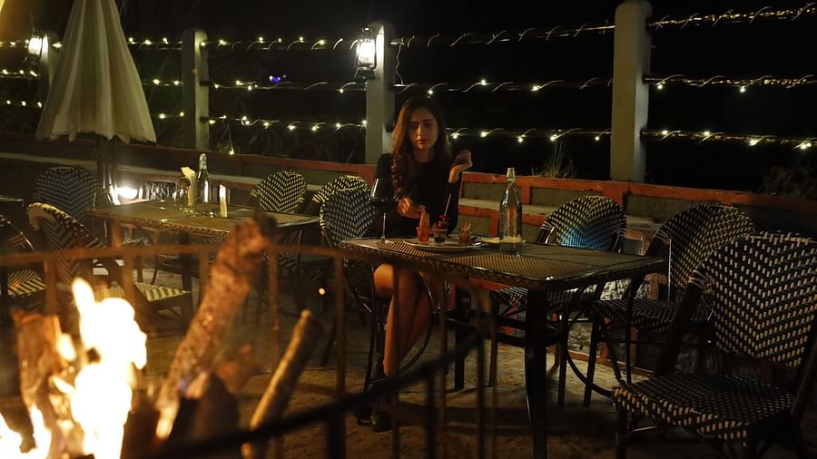 a person eating a meal beside a fire - Polo Cherrapunjee Resort