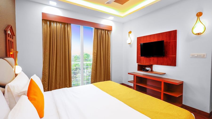 Deluxe room with bed and television at Vagator Downtown, Goa 