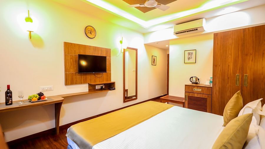 Deluxe room with bed and televison mounted on the wall at Vagator Downtown, Goa 